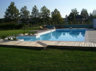 piscina immersa nel verde del giardino circostante curato e tagliato